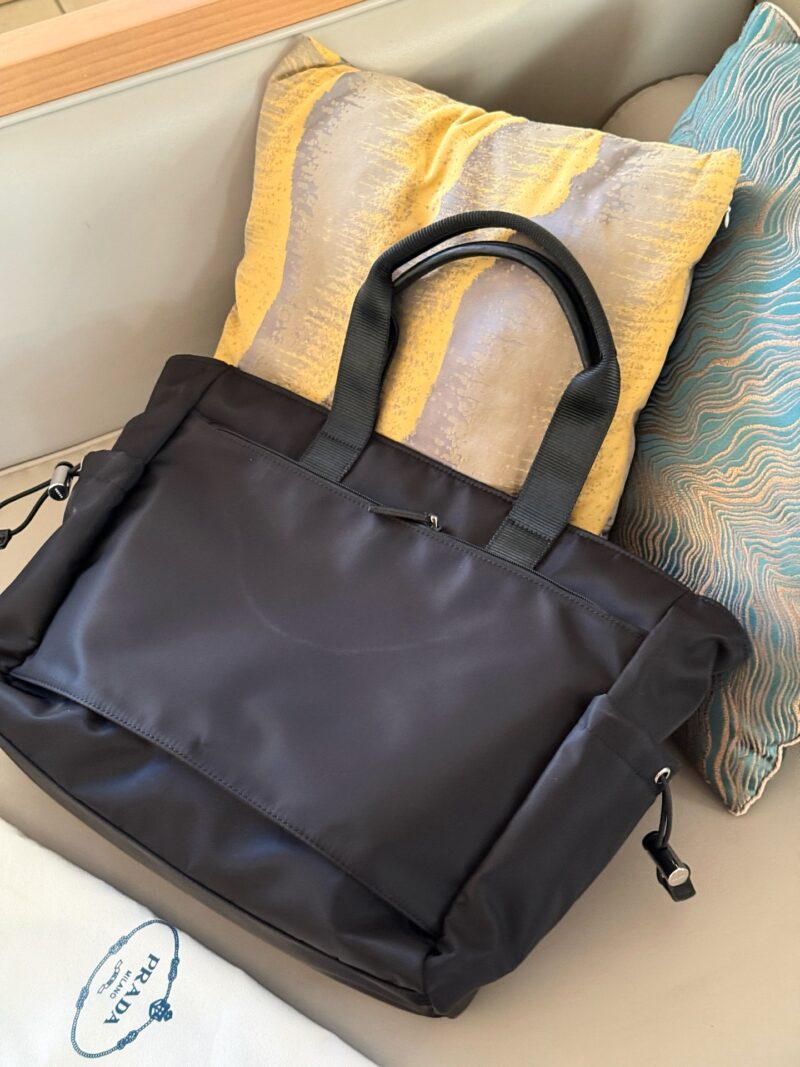 579bccdf1e.jpg 235 without box
size:40*35cm
Prad tote (shopping bag)
The leather material is thick and textured
There are compartments/stickers/it can also be hung on the luggage compartment!
Really practical!!