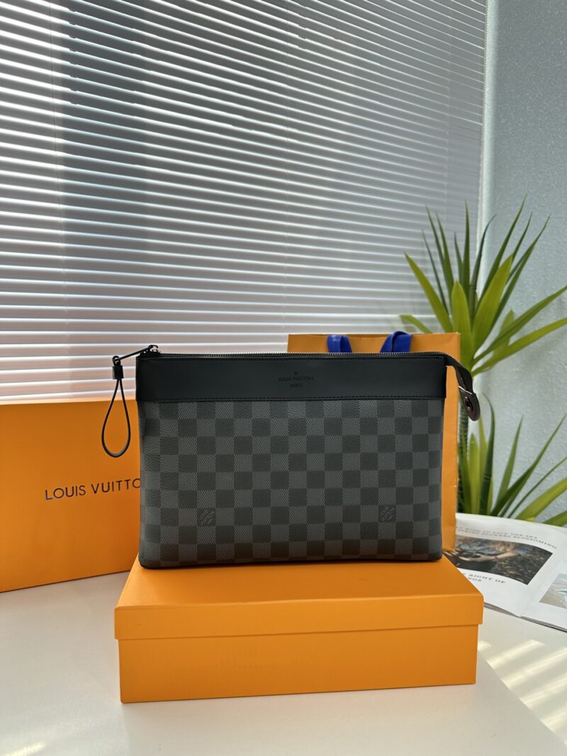 Exclusive real-life shot of M82543 Haige Pochette Voyage Souple handbag with packaging. Made of soft Monogram Eclipse coated canvas, the classic Pochette Voyage handbag lines are outlined with rounded strokes, providing a comfortable travel experienc...