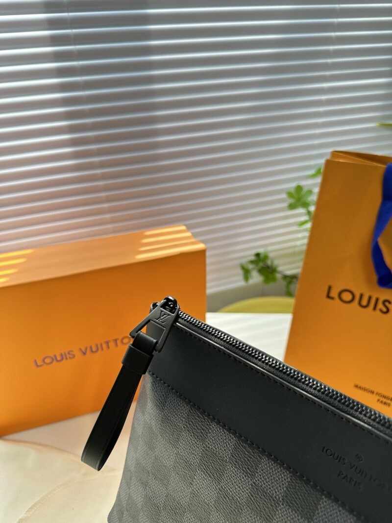 Exclusive real-life shot of M82543 Haige Pochette Voyage Souple handbag with packaging. Made of soft Monogram Eclipse coated canvas, the classic Pochette Voyage handbag lines are outlined with rounded strokes, providing a comfortable travel experienc...