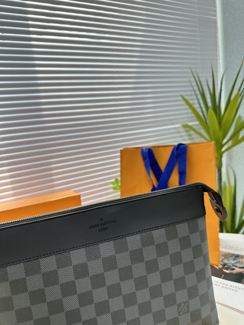 Exclusive real-life shot of M82543 Haige Pochette Voyage Souple handbag with packaging. Made of soft Monogram Eclipse coated canvas, the classic Pochette Voyage handbag lines are outlined with rounded strokes, providing a comfortable travel experienc...