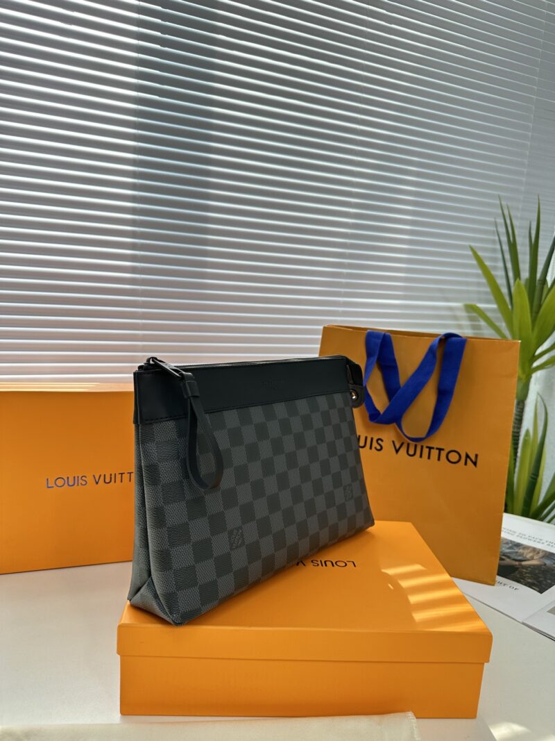 Exclusive real-life shot of M82543 Haige Pochette Voyage Souple handbag with packaging. Made of soft Monogram Eclipse coated canvas, the classic Pochette Voyage handbag lines are outlined with rounded strokes, providing a comfortable travel experienc...